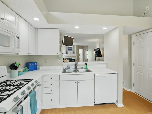 kitchen with light wood-style flooring, a sink, light countertops, recessed lighting, and white appliances