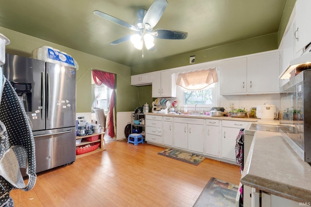 kitchen featuring white cabinets, stainless steel refrigerator with ice dispenser, a ceiling fan, and a healthy amount of sunlight
