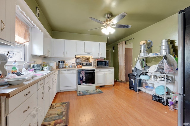 kitchen with white dishwasher, a sink, stainless steel microwave, electric stove, and under cabinet range hood