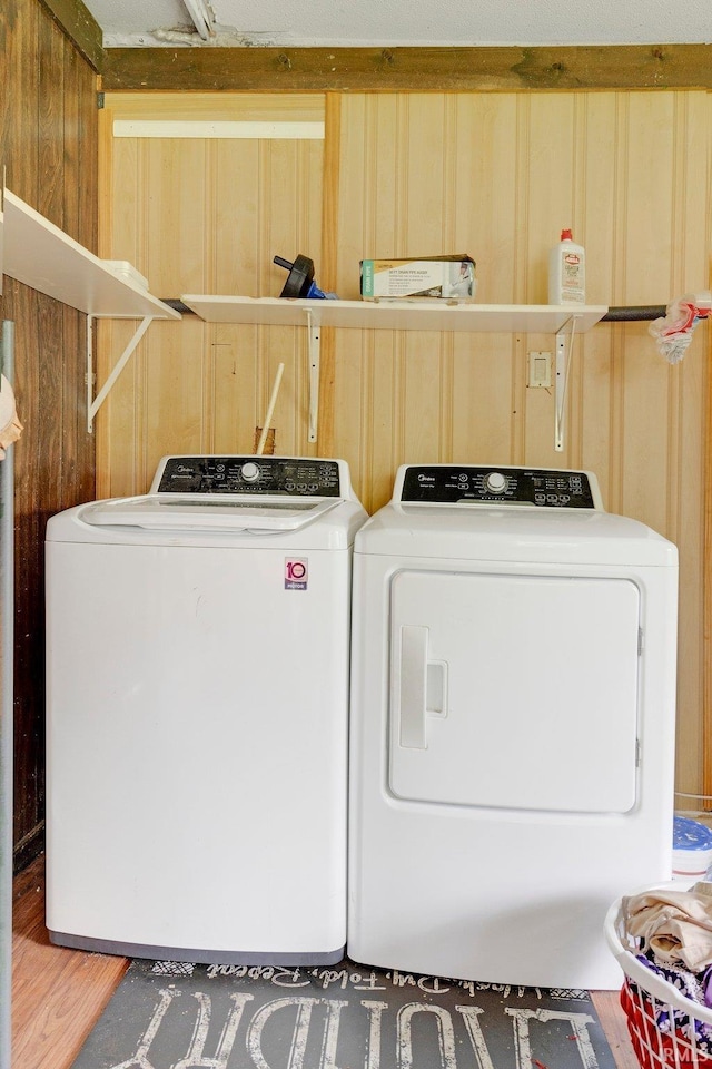 laundry area featuring laundry area, washing machine and dryer, and wood finished floors