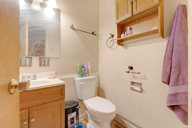 half bathroom featuring vanity and toilet