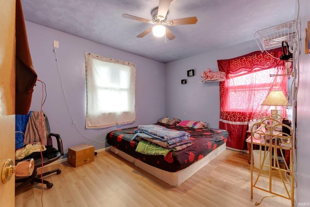 bedroom featuring baseboards, ceiling fan, and wood finished floors