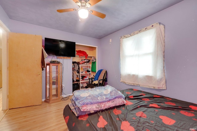 bedroom with a closet, a ceiling fan, and wood finished floors