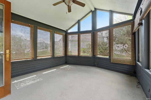 unfurnished sunroom featuring plenty of natural light, ceiling fan, and beamed ceiling
