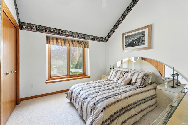 carpeted bedroom with baseboards and vaulted ceiling