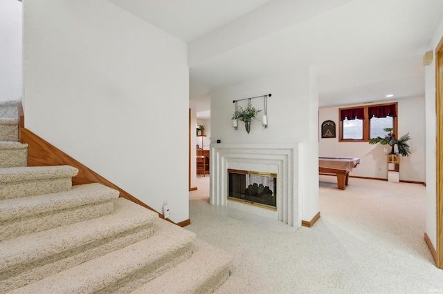 stairway with carpet floors, baseboards, recessed lighting, billiards, and a multi sided fireplace