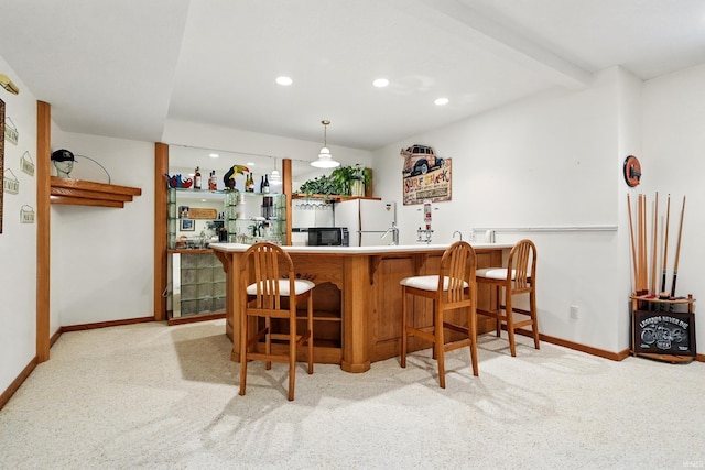 bar featuring black microwave, carpet floors, baseboards, and indoor wet bar