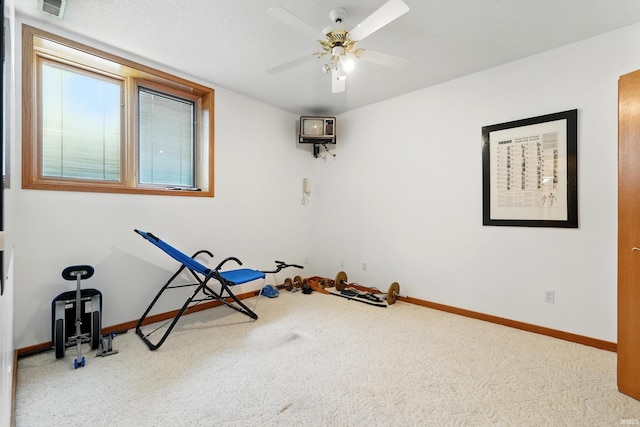 exercise room with baseboards, carpet, ceiling fan, and visible vents