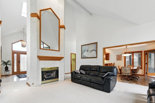 carpeted living area featuring french doors, a premium fireplace, and high vaulted ceiling