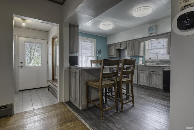 2165 S 625 W, South Whitley, IN 46787 - kitchen with wood finished floors, dishwashing machine, baseboard heating, a sink, and gray cabinetry
