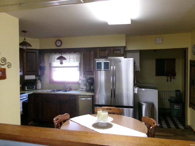 kitchen with a sink, appliances with stainless steel finishes, dark brown cabinets, and light countertops