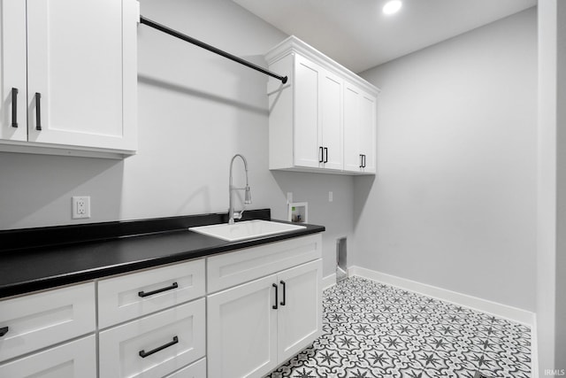 laundry room featuring baseboards, hookup for an electric dryer, a sink, cabinet space, and washer hookup