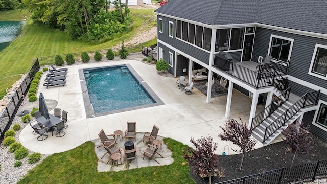 view of swimming pool with stairs, fence, and a patio