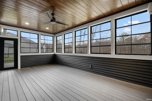 unfurnished sunroom featuring wooden ceiling, a ceiling fan, and a wealth of natural light