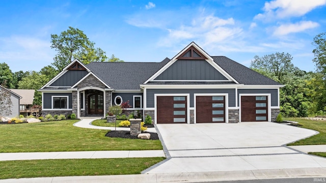 craftsman inspired home with an attached garage, stone siding, board and batten siding, a front yard, and concrete driveway