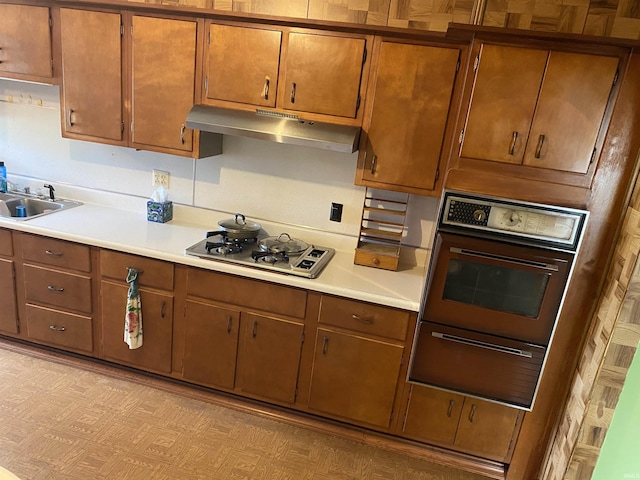 870 W 950 Rd S, Geneva, IN 46740 - kitchen with under cabinet range hood, stainless steel gas cooktop, a sink, and light countertops