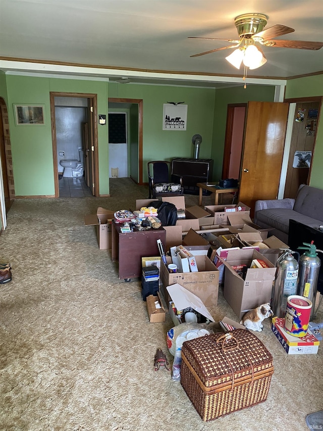 870 W 950 Rd S, Geneva, IN 46740 - carpeted living room featuring crown molding, ceiling fan, and a wood stove