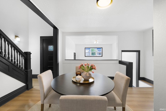 1820 W Main St, Fort Wayne, IN 46808 - dining space with baseboards, stairway, and light wood-style floors
