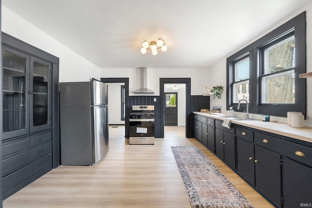1820 W Main St, Fort Wayne, IN 46808 - kitchen featuring light wood-type flooring, a sink, light countertops, stainless steel appliances, and wall chimney exhaust hood