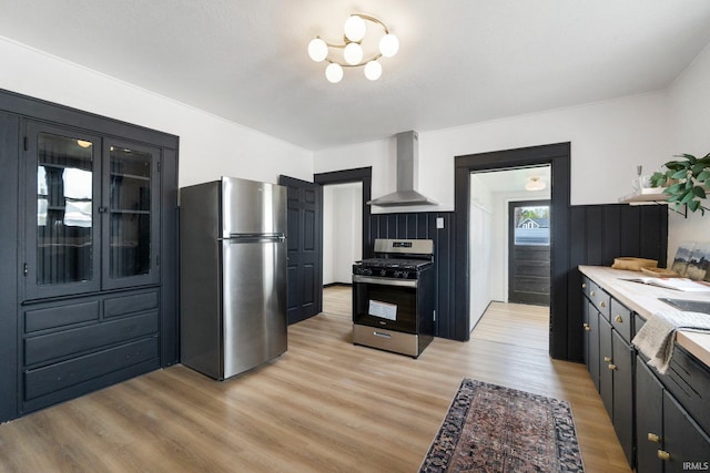 1820 W Main St, Fort Wayne, IN 46808 - kitchen featuring light wood finished floors, light countertops, wall chimney exhaust hood, stainless steel appliances, and glass insert cabinets