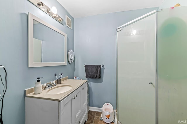 bathroom with vanity, baseboards, and a stall shower