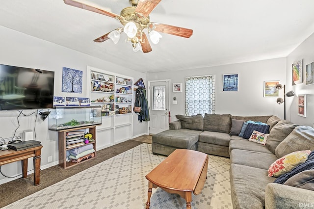 carpeted living area with ceiling fan