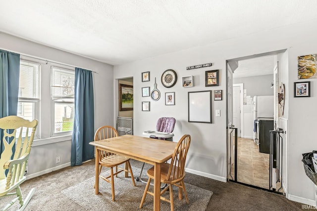 carpeted dining room with baseboards and a textured ceiling