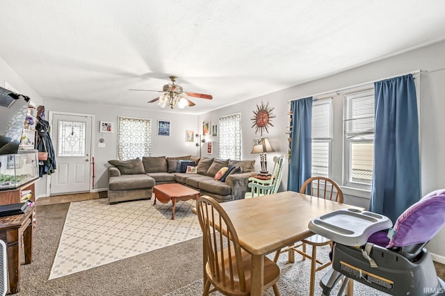carpeted dining area featuring a ceiling fan, a textured ceiling, and a healthy amount of sunlight