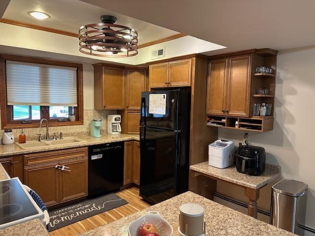 8615 Timbermill Pl, Fort Wayne, IN 46804 - kitchen with black appliances, a sink, light wood-style flooring, crown molding, and brown cabinetry