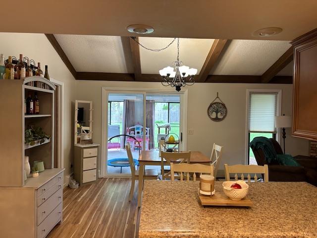 8615 Timbermill Pl, Fort Wayne, IN 46804 - dining area featuring light wood-type flooring, coffered ceiling, a chandelier, and beamed ceiling