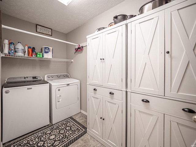 washroom with a textured ceiling, cabinet space, and washer and dryer