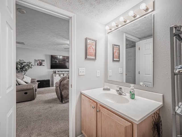 bathroom featuring vanity, a textured ceiling, and visible vents