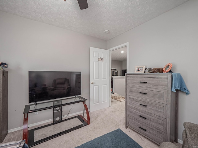 bedroom with carpet flooring, a textured ceiling, ceiling fan, and baseboards