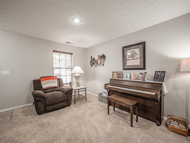 living area featuring baseboards, carpet, a textured ceiling, and visible vents