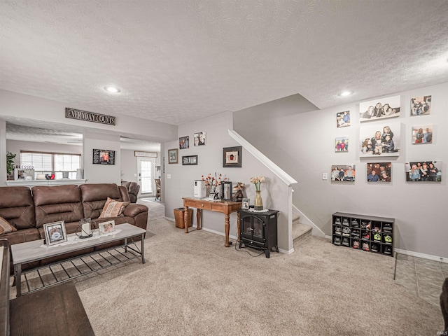 carpeted living area with stairway, baseboards, recessed lighting, and a textured ceiling