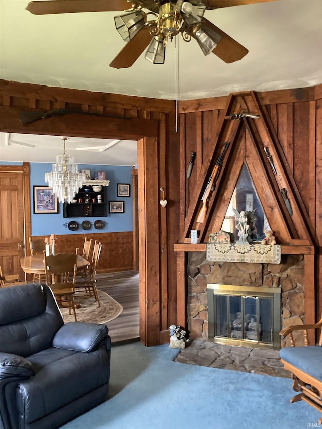 321 S Court St, Sullivan, IN 47882 - living area with carpet flooring, wood walls, ceiling fan with notable chandelier, and a fireplace