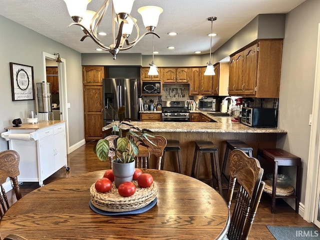 dining space with recessed lighting, baseboards, a notable chandelier, and dark wood-style floors