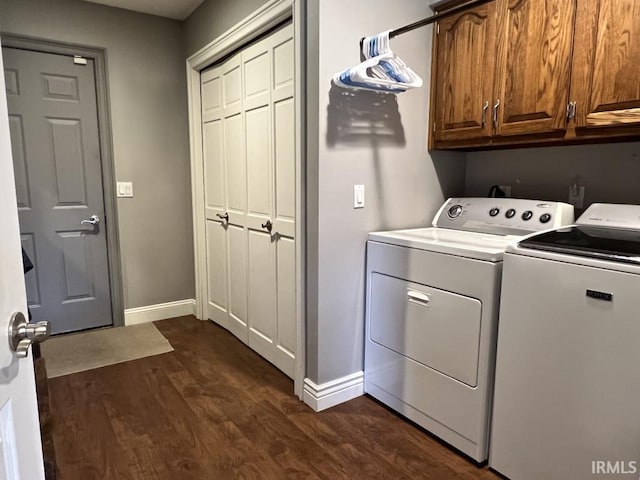 washroom featuring washing machine and clothes dryer, baseboards, dark wood finished floors, and cabinet space