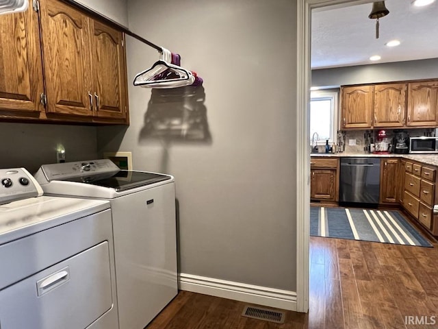 clothes washing area with cabinet space, separate washer and dryer, visible vents, and dark wood-style floors