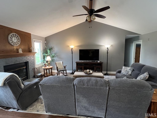 living area with ceiling fan, a fireplace, wood finished floors, baseboards, and lofted ceiling