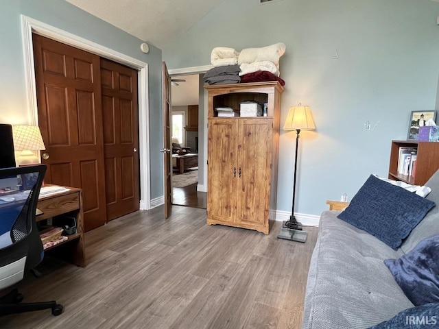 home office with baseboards, light wood finished floors, and lofted ceiling