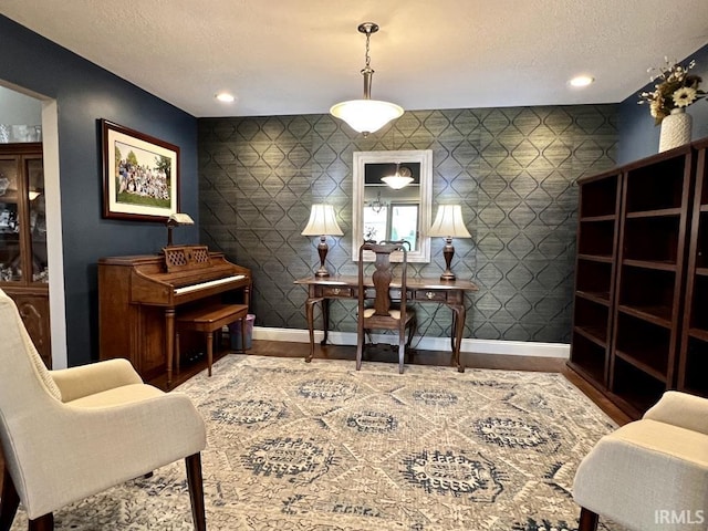 living area featuring baseboards, a textured ceiling, recessed lighting, and wood finished floors