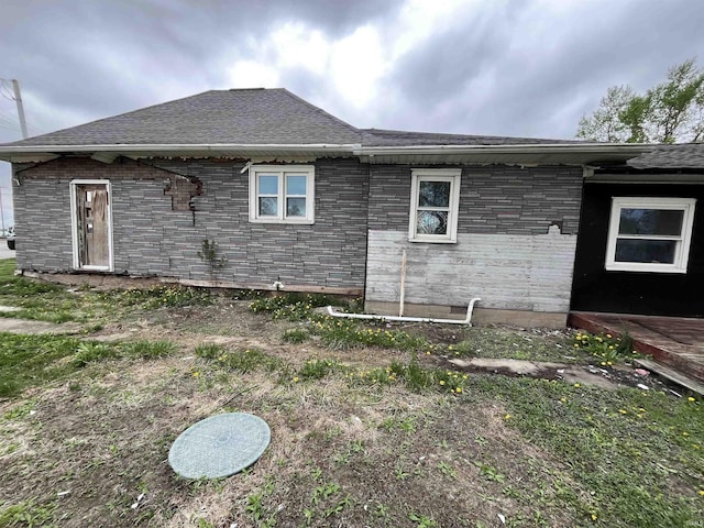 back of house with roof with shingles