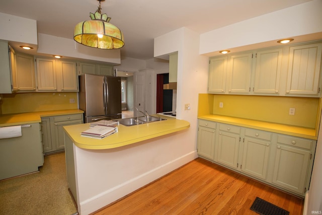 113 W N Shore Dr, South Bend, IN 46617 - kitchen with freestanding refrigerator, a peninsula, light wood-type flooring, light countertops, and a sink