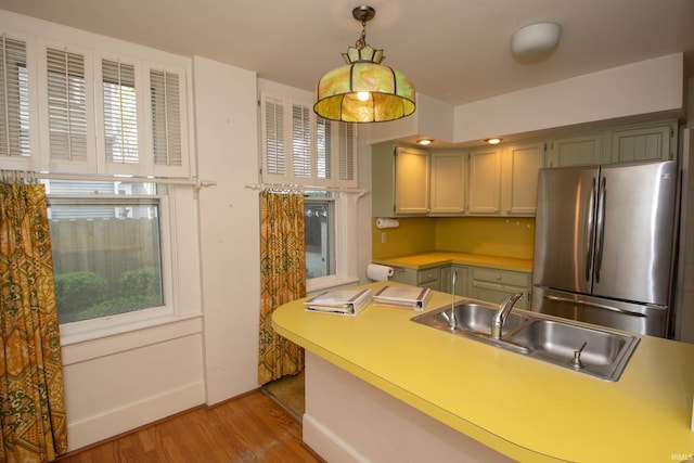 113 W N Shore Dr, South Bend, IN 46617 - kitchen featuring decorative light fixtures, light wood-type flooring, a sink, light countertops, and freestanding refrigerator