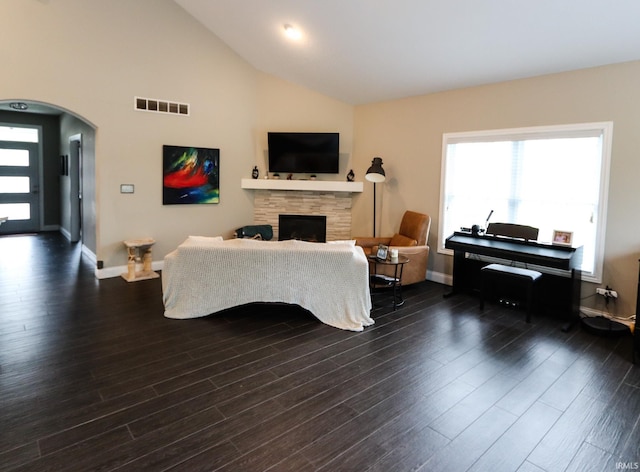 living room with visible vents, baseboards, dark wood-style flooring, and a fireplace