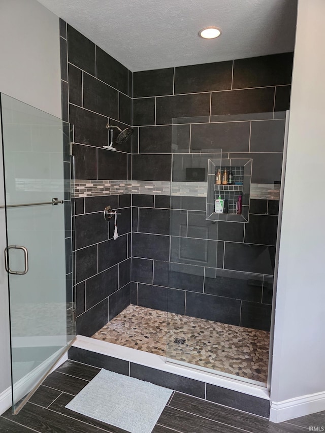 full bath with wood finished floors, recessed lighting, baseboards, and a stall shower