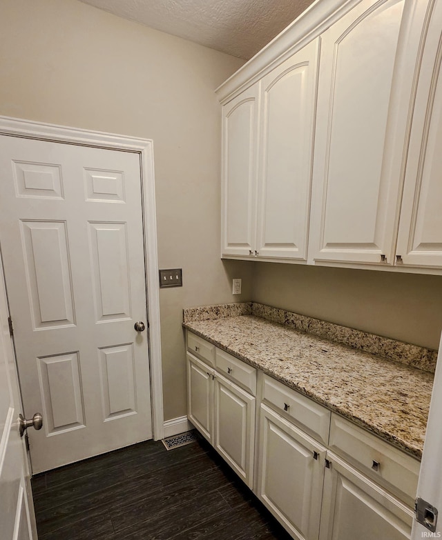 washroom featuring baseboards and dark wood finished floors