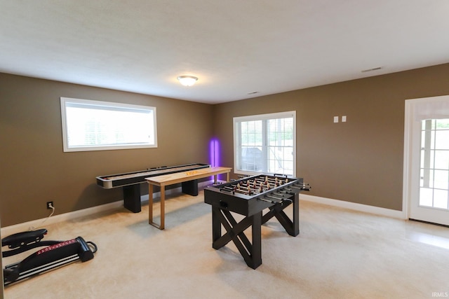 rec room featuring baseboards, a wealth of natural light, and light carpet