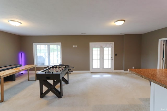 recreation room featuring a healthy amount of sunlight, baseboards, and light carpet